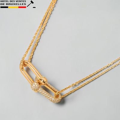 gros plan d'un collier en or sur une surface blanche
