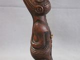 wooden statue of a cat holding a fish on its back