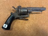 un vieux pistolet avec une étiquette, posé sur une table