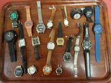 many different watches on a tray on the table