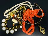de nombreux colliers et bracelets de styles variés posés sur un fond noir