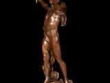 bronze statue of a woman holding a bird on a black background