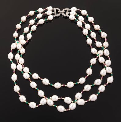 a necklace with pearls and emeralds on a black background