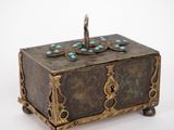an antique brass box with turquoise stones on top of it
