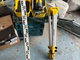 a measuring tape on the ground next to a pile of tools