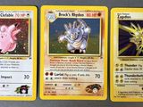 trois cartes Pokémon aux motifs différents posées sur une table