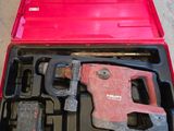 une trousse à outils dans une mallette rouge posée par terre