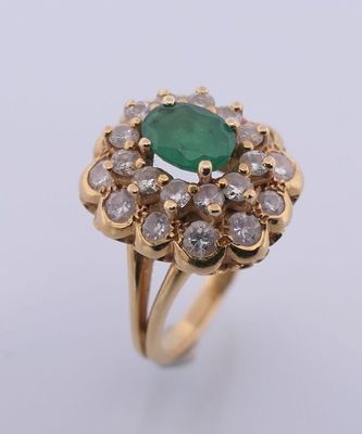 gros plan d'une bague avec une pierre verte entourée de diamants