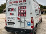 a van parked in a parking lot with a ladder attached to the back of it