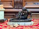 une statue représentant un homme aux prises avec une femme sur une table