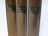 three books sitting on top of each other on a white surface