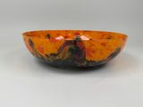 bol orange et noir sur une surface blanche
