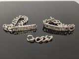 deux bijoux en argent posés sur une table noire