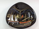 a black plate with a picture of a boat on it