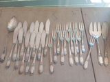 a lot of spoons and forks laid out on a table