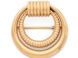 a close up of a gold broochle with a circular design