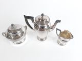 trois théières en argent posées sur une table blanche