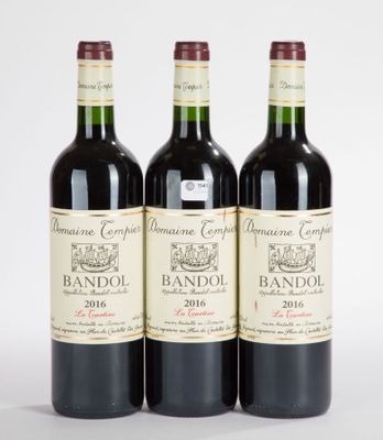 trois bouteilles de vin rouge posées l'une à côté de l'autre sur une surface blanche