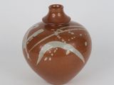 a brown vase with white designs on it on a white surface