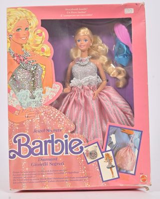 La poupée Barbie se trouve dans une boîte rose posée sur une surface blanche
