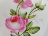 a white vase with pink flowers painted on it