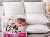deux oreillers sur un lit, sur lequel est posée une boîte d'oreillers