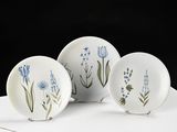 three white plates with blue flowers on them sitting on a table