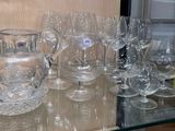 bottles and glasses on a glass shelf in a room