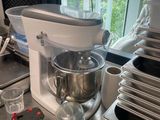 un mixeur posé sur un plan de travail, à côté d'un tas de casseroles