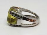 une image d'une bague avec une pierre verte entourée de diamants blancs