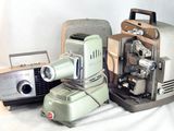 deux vieux appareils photo et un vieux projecteur posés sur une table