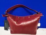 a red purse with a tag on it sitting on a table