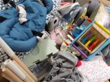 a baby in a stroller next to a pile of toys