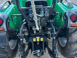une photo d'un tracteur vert garé sur un parking