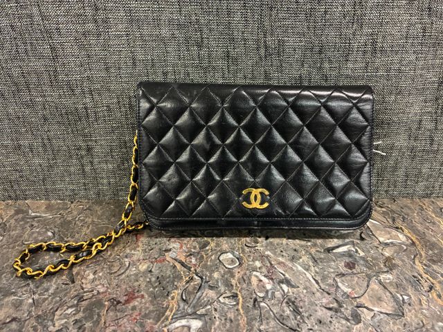 CHANEL - Sac en cuir noir matelassé, fermoir sigle en métal doré ...