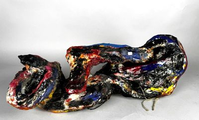 une sculpture représentant un serpent allongé sur le sol