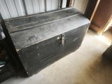 a black chest sitting in a room next to a door