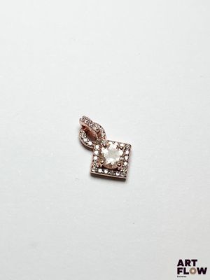 un gros plan d'un pendentif en forme de cœur en diamant posé sur une surface blanche