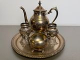 a silver tea set on a silver tray on a table