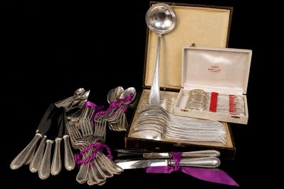 un assortiment de couverts dans une boîte ornée d'un ruban violet