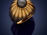 a gold ring with a pearl in the center