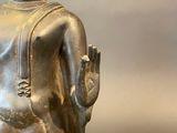 statue of a seated buddha with a raised arm and a raised hand