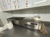 stainless steel counter top in a restaurant kitchen with a roll of toilet paper on the counter