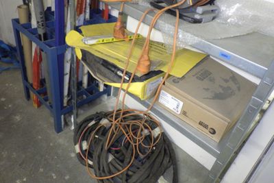 tout un tas de câbles posés sur une étagère dans un garage