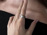 une femme en robe noire, avec une bague au doigt