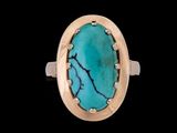 un gros plan d'une bague sertie d'une pierre turquoise sur fond noir