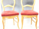deux chaises en bois avec des coussins rembourrés rouges et des bordures dorées