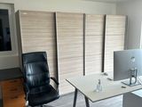 a desk with a computer and a chair in a room