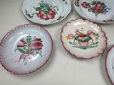 four plates with flowers on them sitting on a table