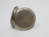 a close up of a silver pocket watch on a white surface